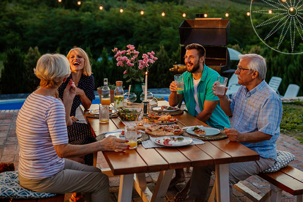 group of people having dinner at a table outdoors